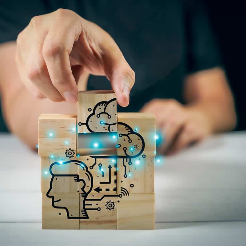 A person is holding a neurotech project involving a wooden block with a drawing on it.