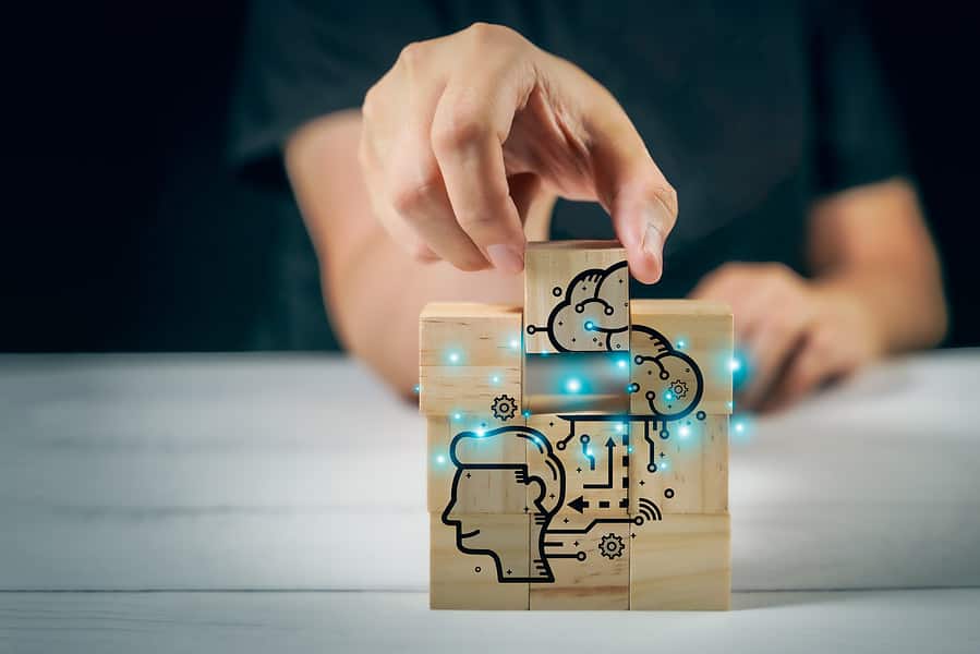 A person is holding a neurotech project involving a wooden block with a drawing on it.