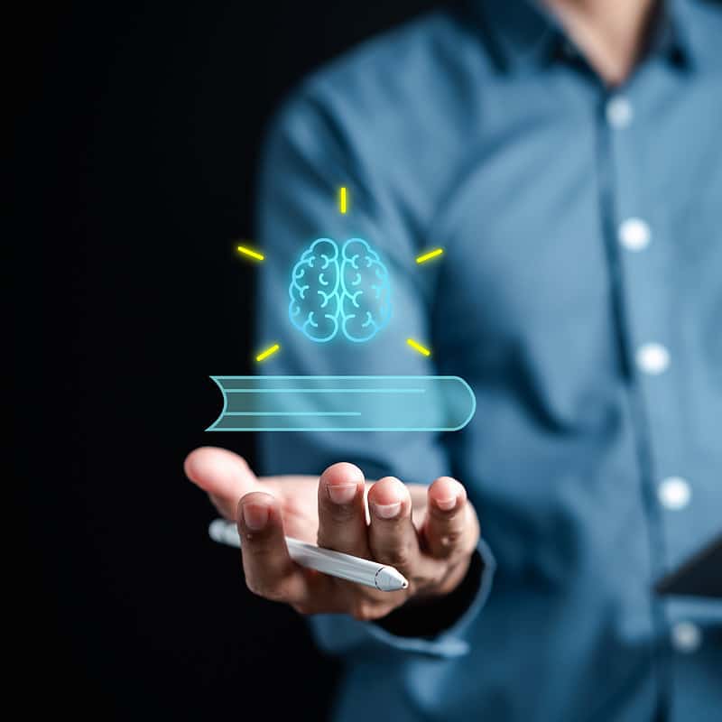 A man holding a tablet with a brain on it, showcasing his EEG skills.