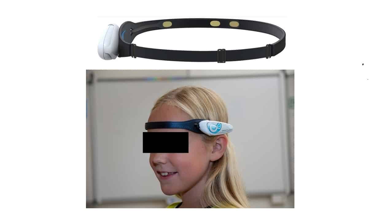 A young individual wearing a head-mounted device with an adjustable strap and a white, futuristic-looking gadget positioned over the forehead, possibly for virtual reality, augmented reality experiences, or non-invasive neurotechnology applications